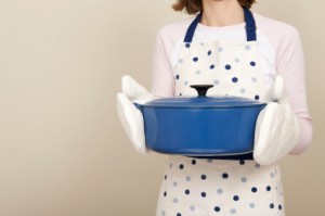 Anonymous woman holding a blue cast iron casserole dish