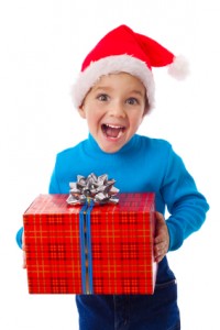 Laughing boy in Santa hat with red box